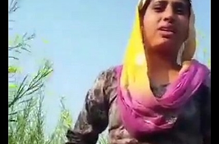 Desi girl removing clothes in field.